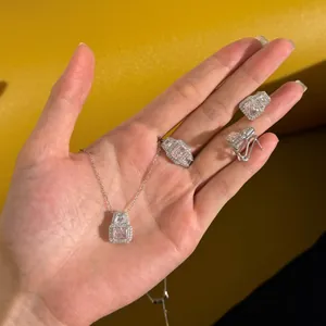 Detailed close-up of pink rectangle crystal jewelry set held by hand against yellow backdrop