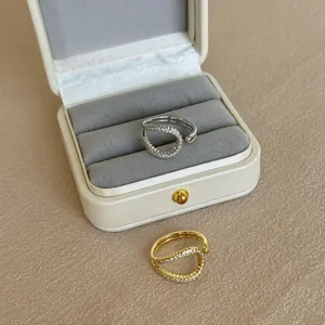 Detail view of gold and silver layered rings with pavé cubic zirconia in a jewelry box