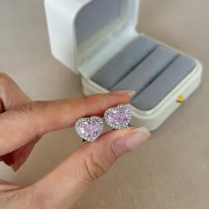 Detail of pink heart-shaped stud earrings with sparkling white cubic zirconia halo