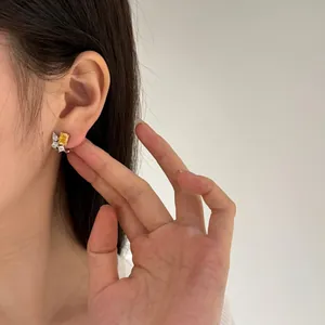 Close-up of S925 silver earrings with yellow rectangular zircon and white pear-cut stones