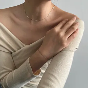 Conjunto de collar y pulsera minimalista de plata de ley S925 usado por una modelo