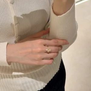 Close-up of gold flower ring with micro-pave cubic zirconia on a model finger