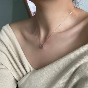 Close-up of S925 silver necklace with pink rectangular zircon pendant on a model neck