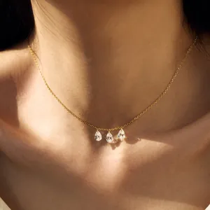 Elegant gold chain necklace with three sparkling pear-cut zircon pendants on a model