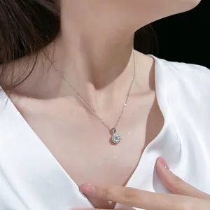 Close-up of S925 silver necklace with sparkling round zircon pendant on a female model