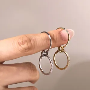 Detailed view of S925 sterling silver and gold rings with dangling cubic zirconia charms
