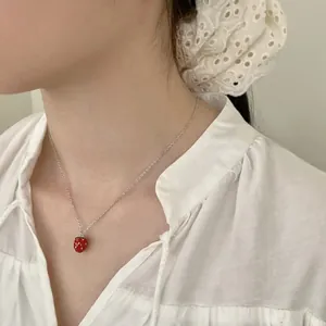 Elegant model wearing a 3D red strawberry pendant necklace on a silver chain
