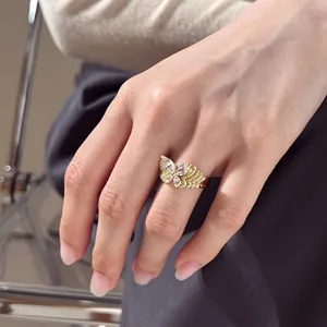 Détail d'une bague papillon dorée de luxe avec zircons poire portée à la main