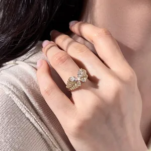 Bague papillon en or élégante ornée de zircons blancs portée sur un doigt féminin