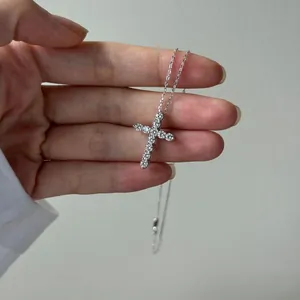 Détail macro d'un pendentif croix en argent 925 avec 11 moissanites rondes taille brillant