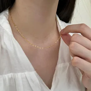 Primer plano de un delicado collar S925 dorado con eslabones en forma de corazón