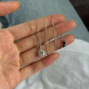 Gros plan d'un pendentif halo en argent S925 avec une pierre centrale ronde étincelante