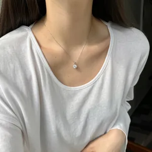 Collar con colgante solitario de moissanita en modelo con una camiseta blanca