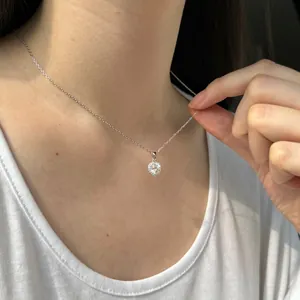 Gros plan du collier pendentif cœur en argent S925 avec une moissanite ronde brillante
