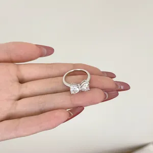 Elegante anello in argento S925 con pietre a forma di cuore e design a fiocco sulla mano