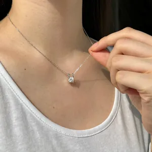 Gros plan d'un collier en argent s925 avec pendentif moissanite rond au cou