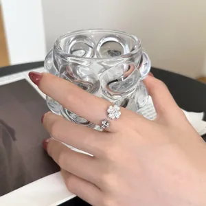 Detail of S925 sterling silver clover ring with white zircon on a model's finger