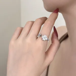 Close-up of a silver S925 clover ring with sparkling zircon inlays on a hand