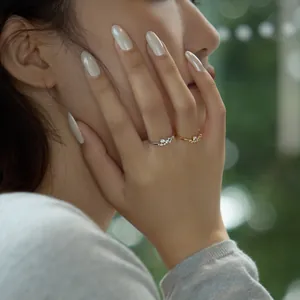 Gros plan de bagues élégantes en argent S925 et or avec zircons sur une main de femme