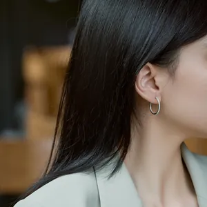 Créoles minimalistes en argent S925 avec pavé de zircons blancs portées par un mannequin