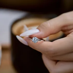 Macro shot of a sparkling six-prong round zircon solitaire ring on a finger