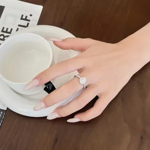 Elegante anello in argento S925 con halo a goccia indossato in un contesto di caffè