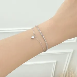 Detail of s925 sterling silver double-layer bracelet with square zircon on female wrist