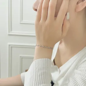 Detail of S925 sterling silver paperclip chain bracelet with textured oval links on wrist