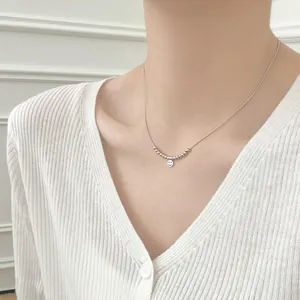 Close-up of S925 sterling silver smiling face pendant necklace worn by a model