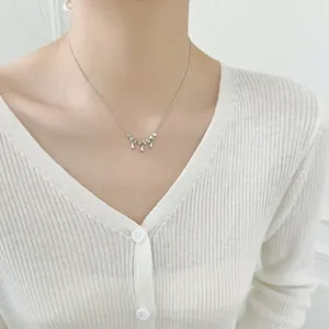 Close-up of S925 sterling silver necklace with cat-eye beads and teardrop pendant on model