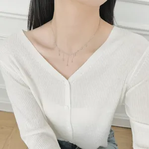 Close-up of S925 sterling silver beaded tassel necklace on a model wearing white knitwear