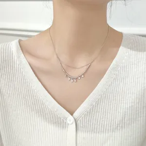 Close-up of double-layered S925 silver star pendant necklace on a female model
