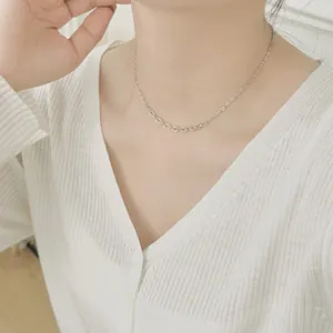 Close-up of minimalist S925 sterling silver paperclip chain necklace worn by a model