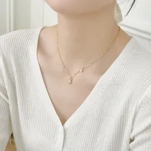 Close-up of a silver bear pendant necklace with a round sparkling zircon on woman neck