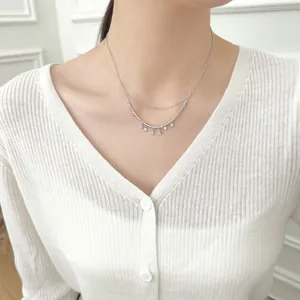 Double-layer S925 sterling silver necklace with star pendants on an elegant female model