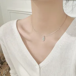 Close-up of a S925 sterling silver oval pendant with starburst engraving on a neck