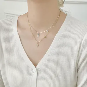 Close-up of double layer silver and gold necklaces with diamond teddy bear pendants