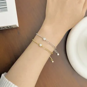 Detail of S925 sterling silver paperclip bracelet with round zircon bead on wrist