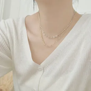 Detail shot of a layered S925 sterling silver heart necklace set on a model