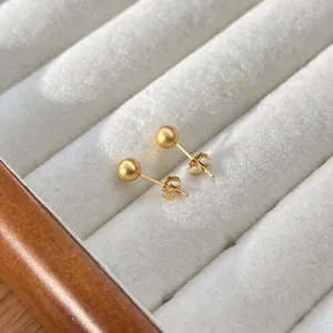 Makroaufnahme matter goldener S925 Sterlingsilber Kugelohrstecker mit Schmetterlingsverschluss