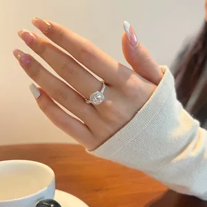Vista macro del anillo halo de plata S925 con moissanita en la mano de una modelo real