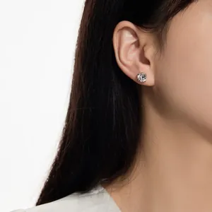 Gros plan d'un modèle portant de petites puces d'oreilles rondes en argent S925 avec serti 4 griffes