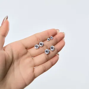 Trois paires de puces d'oreilles en argent S925 présentées sur main pour taille réelle
