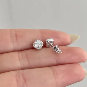 Close-up of S925 silver stud earrings with cushion-cut moissanite held by hand