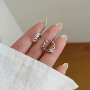 Close-up of S925 sterling silver hoop earrings with round cut stones and bubble texture