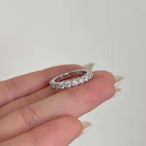 Close-up of a shimmering moissanite eternity ring featuring claw-set round cut stones
