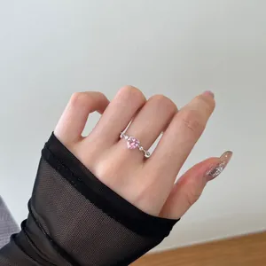 Pink heart-shaped gemstone ring with micro-pave zircons worn on hand for display