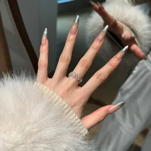 Detail van zilveren bloemenring met fonkelende zirkonia op de vinger bij een spiegel