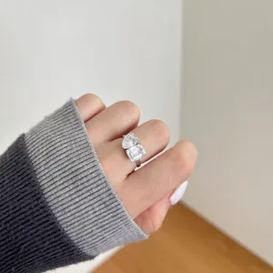 Nahaufnahme eines silbernen Toi-et-Moi-Rings mit Tropfen- und Smaragdschliff am Finger