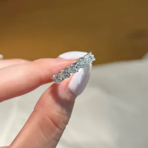 Silver row ring featuring five heart-cut moissanite stones in a prong setting
